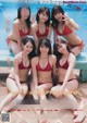 A group of women in bikinis posing by a swimming pool.