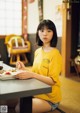 A woman sitting at a table with a plate of food.