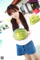 A woman holding a watermelon in her hands.