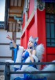 A woman in a blue and white outfit sitting on a bench.