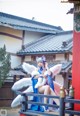 A woman in a blue and white outfit sitting on a bench.