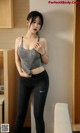 A woman in a gray tank top and black leggings posing for a picture.